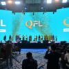 Presentation event for the Qazaqstan Football League with large QFL logo on screen, confetti, and people on stage.